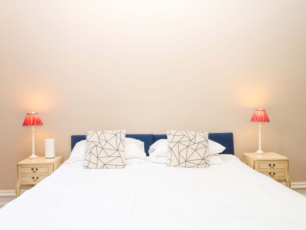 A bedroom with a bed and nightstands at Alston Hall near Mothecombe Beach