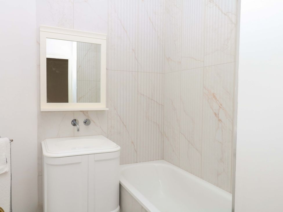 A bathroom with a bathtub and a sink at Alston Hall near Mothecombe Beach