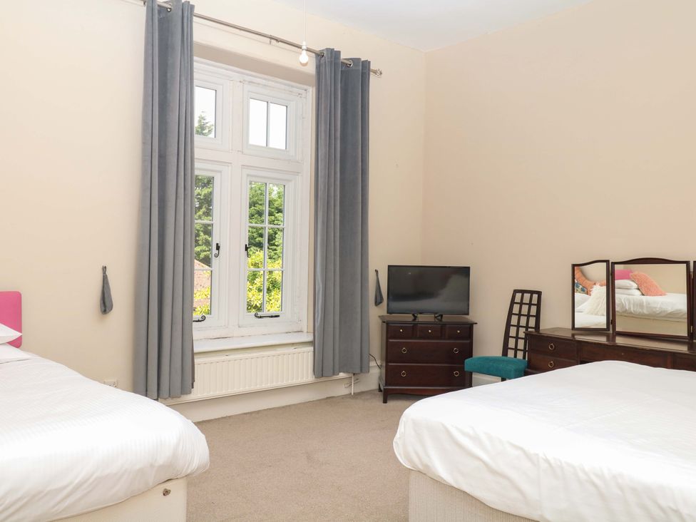 A bedroom with two beds and a television at Alston Hall near Mothecombe Beach