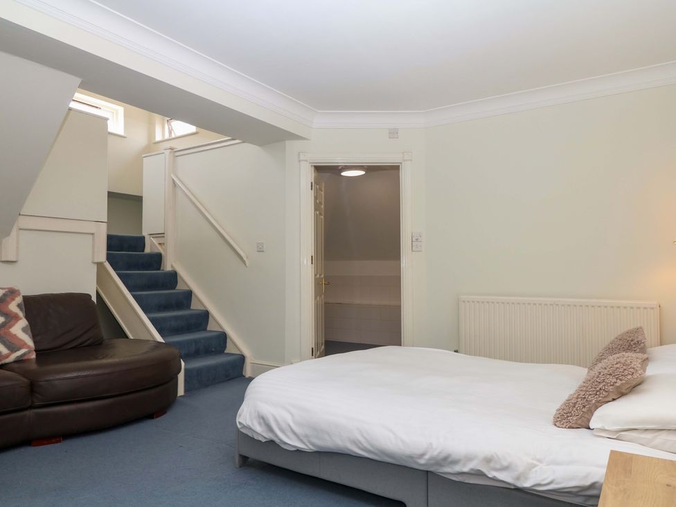 A bedroom with a bed and sofa at Alston Hall near Mothecombe Beach