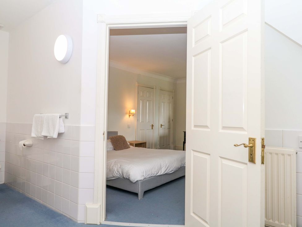 A bedroom with a bed and a table at Alston Hall near Mothecombe Beach