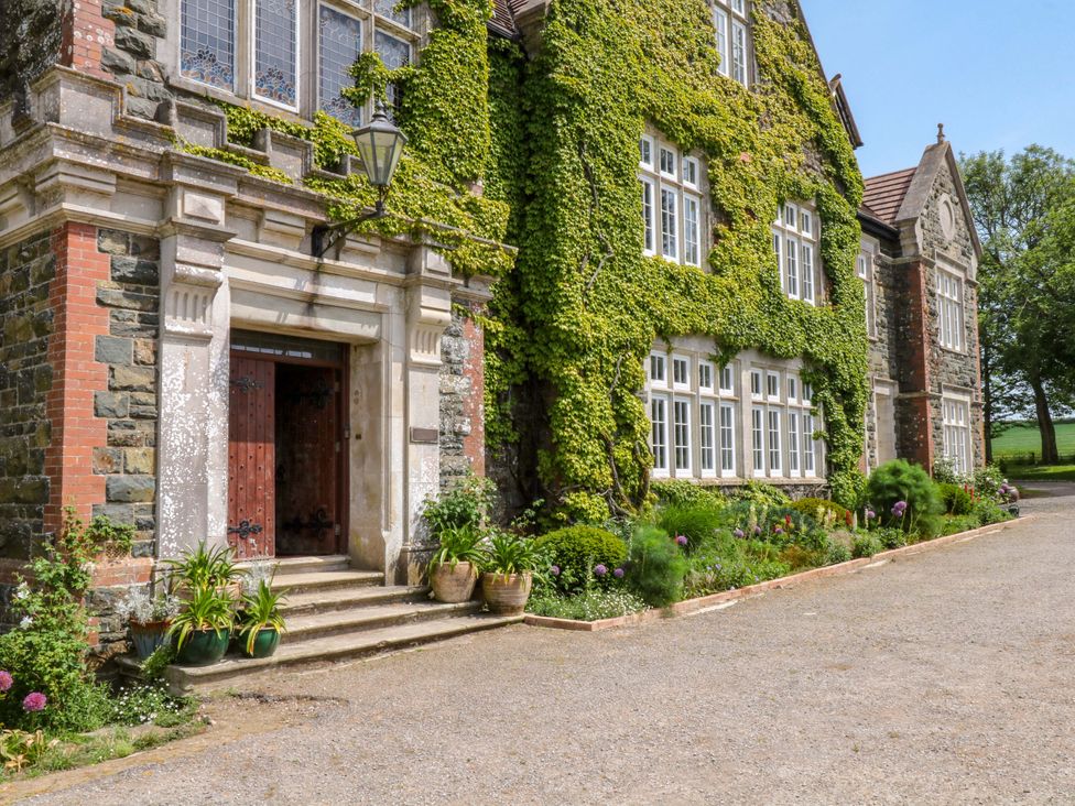 An entrance with ivy-covered walls and a wooden door at Alston Hall near Mothecombe Beach