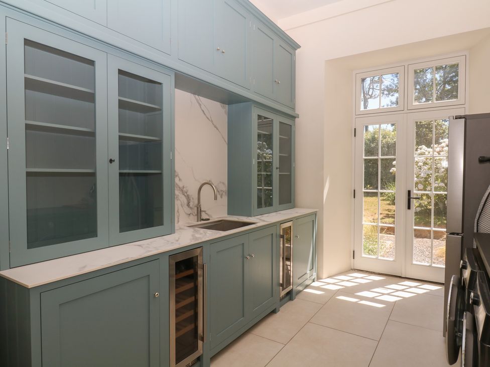 A kitchen with cabinets and a sink at Alston Hall near Mothecombe Beach