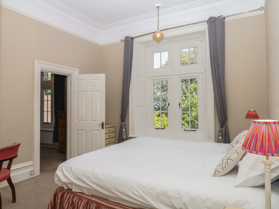 A bedroom with a bed and a lamp at Alston Hall near Mothecombe Beach