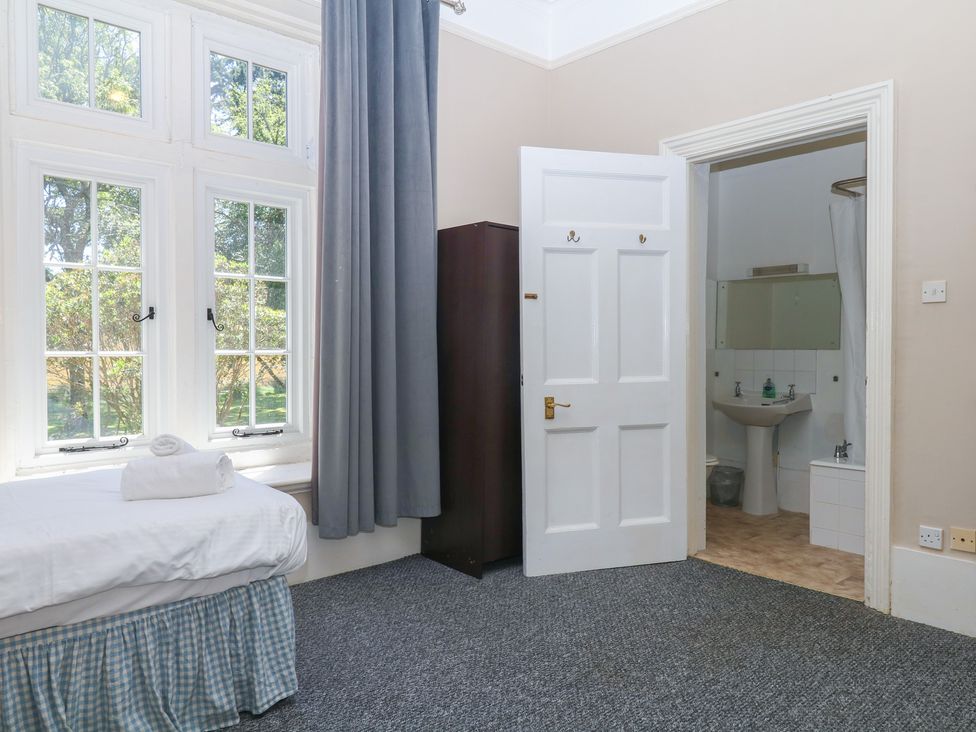 A bedroom with a bed and wardrobe at Alston Hall near Mothecombe Beach