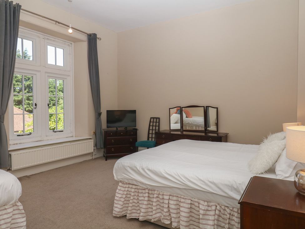 A bedroom with two beds and a television at Alston Hall near Mothecombe Beach