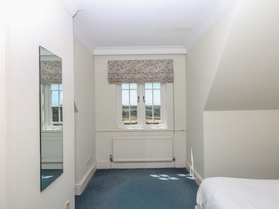 A bedroom with a window and a mirror at Alston Hall near Mothecombe Beach