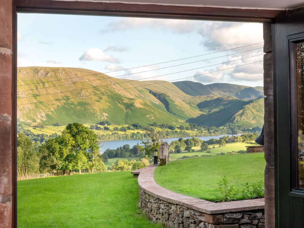 A view of mountains and a lake from a stone wall at Bank Barn, Wreay Watermillock