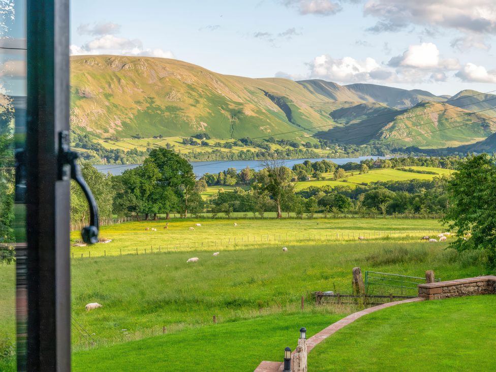 A view of mountains and a lake with sheep grazing at Bank Barn, Wreay Watermillock