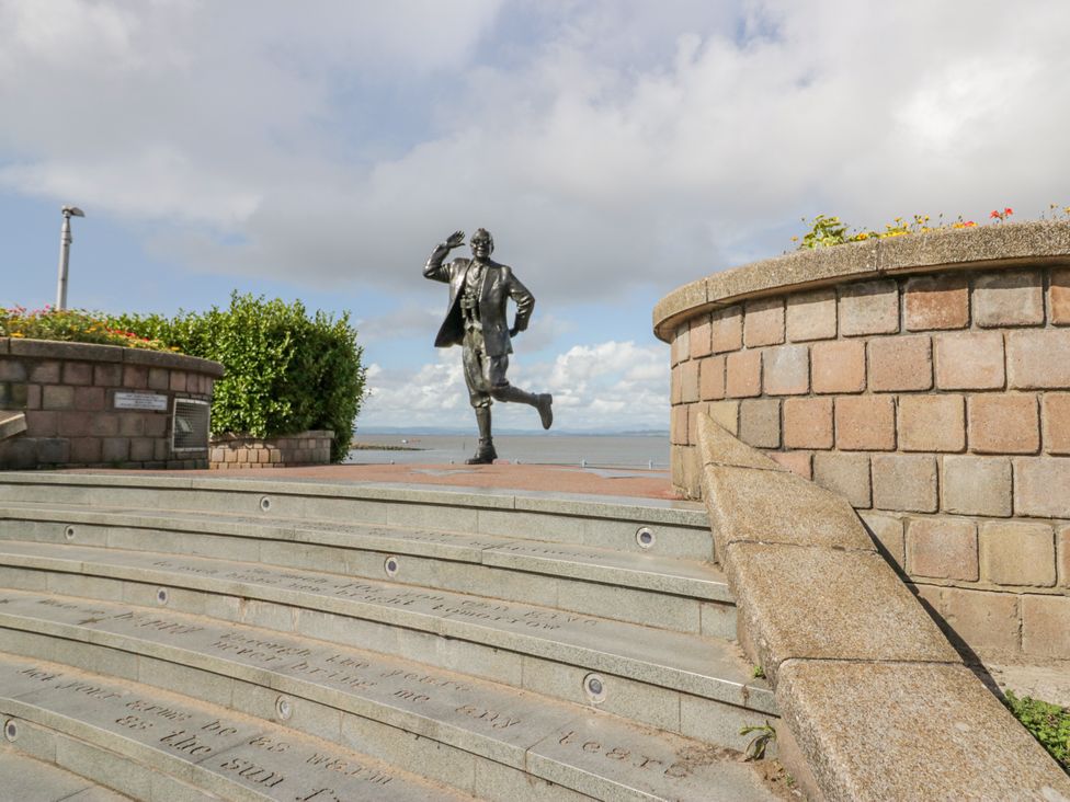 A statue on steps with greenery and sky at Cockle Bay Cottage in Heysham