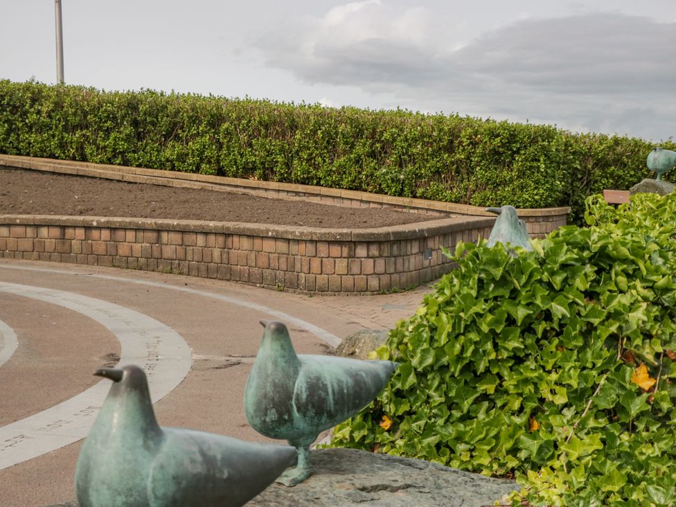 A park with bird statues and greenery at Cockle Bay Cottage in Heysham