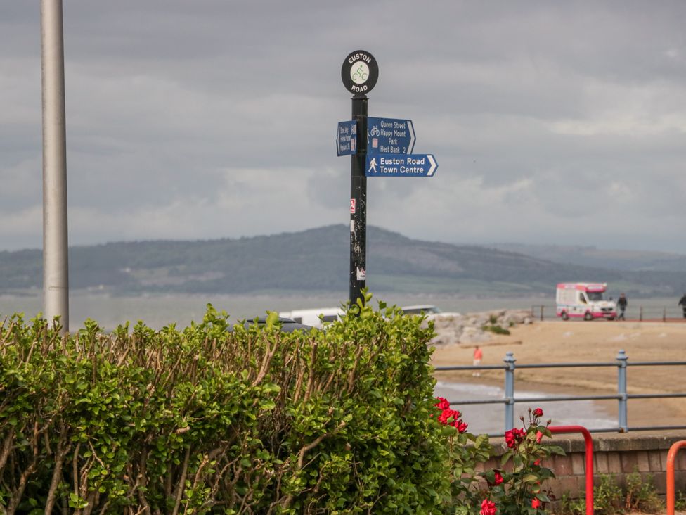 A signpost with directions near a beach at Cockle Bay Cottage in Heysham