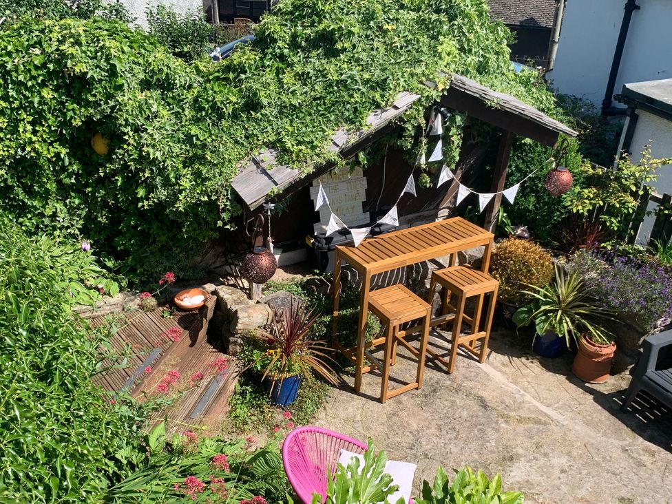 A garden with table and stools at Cockle Bay Cottage in Heysham