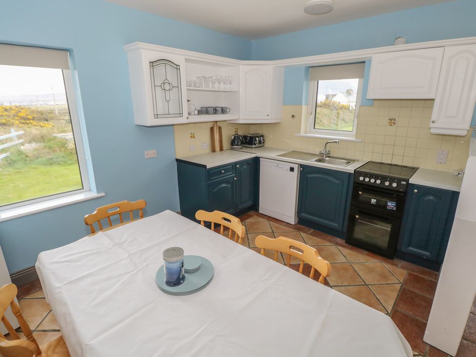 A kitchen with a table and chairs at No.5 Beach Cottages in Keel, County Mayo