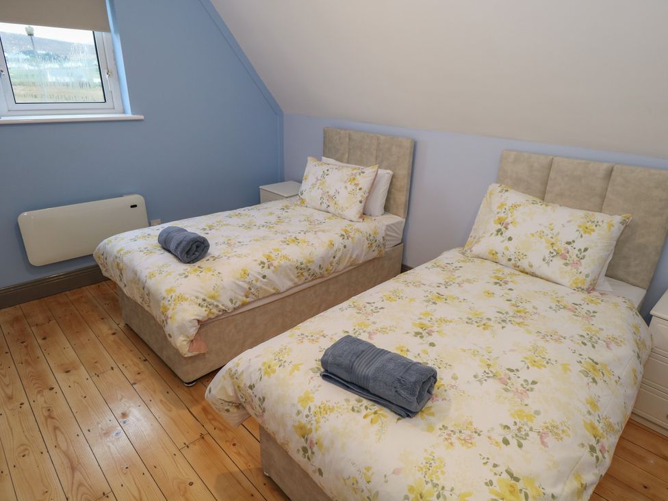 A bedroom with two beds and towels at No.5 Beach Cottages in Keel, County Mayo