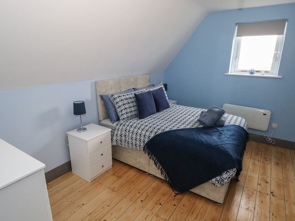 A bedroom with a bed and bedside table at No.5 Beach Cottages, Keel, County Mayo