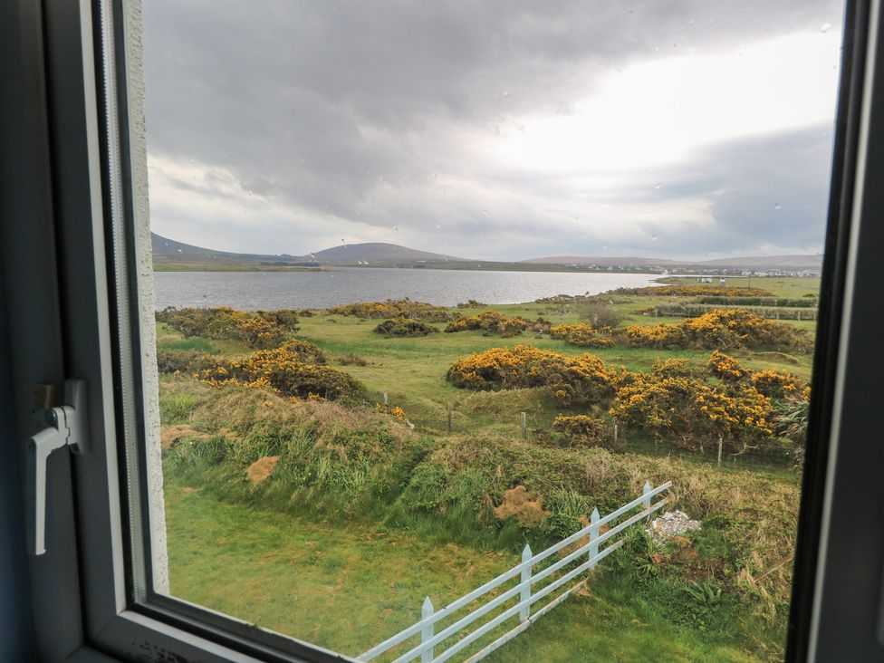 A view of landscape with water and greenery from a window at No.5 Beach Cottages in Keel, County Mayo