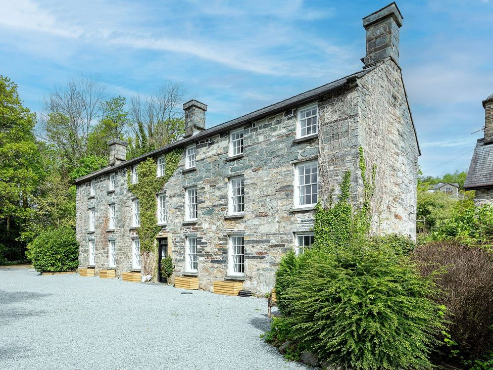 A stone building with windows and a door at Snowdonia Manor in Dolgellau