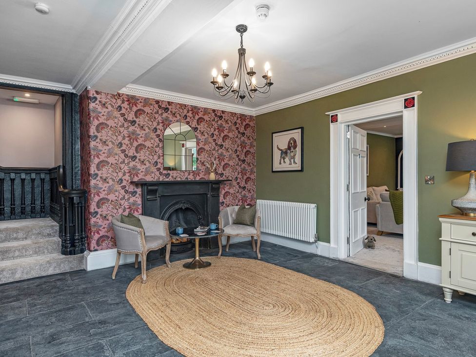 A hallway with a staircase and fireplace at Snowdonia Manor in Dolgellau