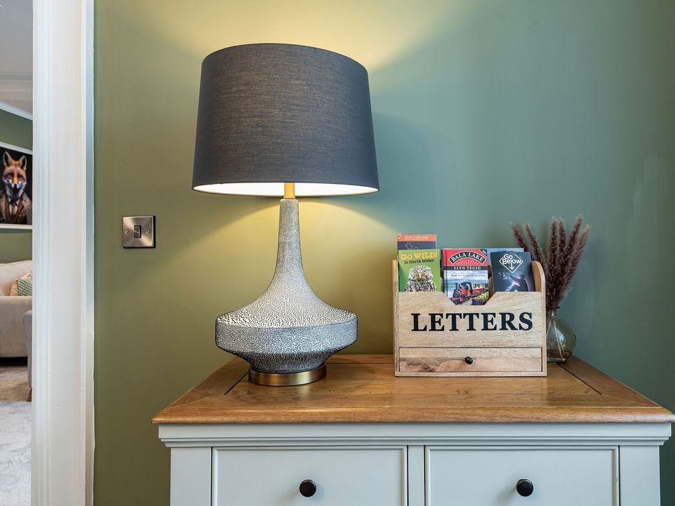 A table lamp and a letters box on a surface in the living room at Snowdonia Manor Dolgellau