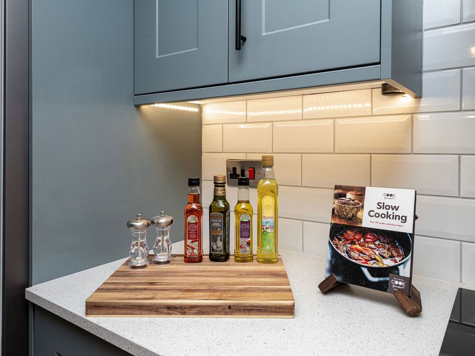 A kitchen counter with oils and a cookbook at Snowdonia Manor in Dolgellau