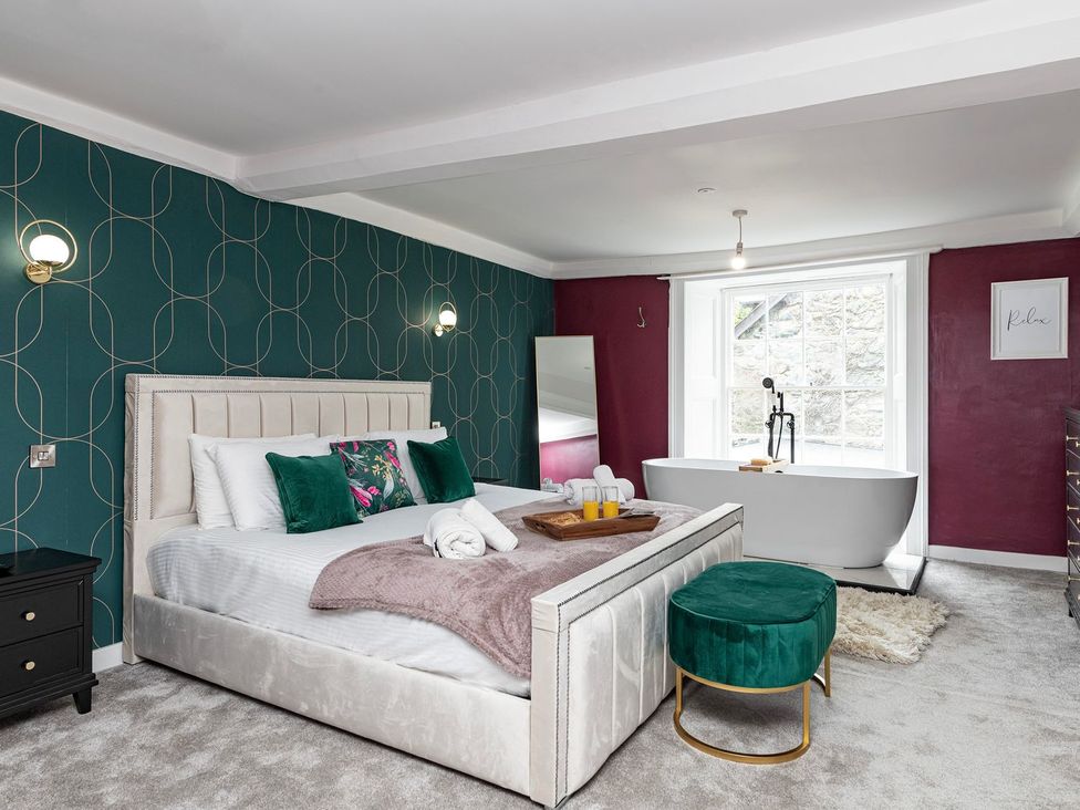 A bedroom with a bed and a bathtub at Snowdonia Manor in Dolgellau