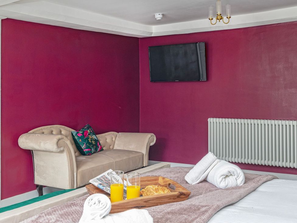 A bedroom with a sofa and TV at Snowdonia Manor in Dolgellau