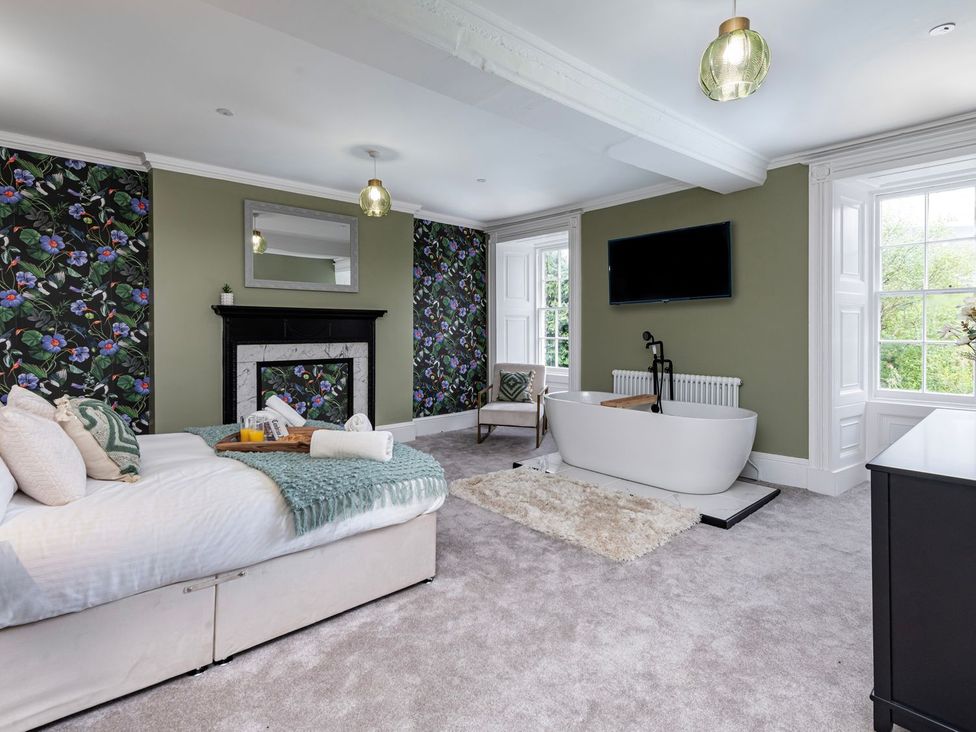 A bedroom with a bathtub and television at Snowdonia Manor in Dolgellau