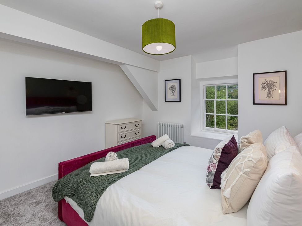 A bedroom with a bed and television at Snowdonia Manor in Dolgellau