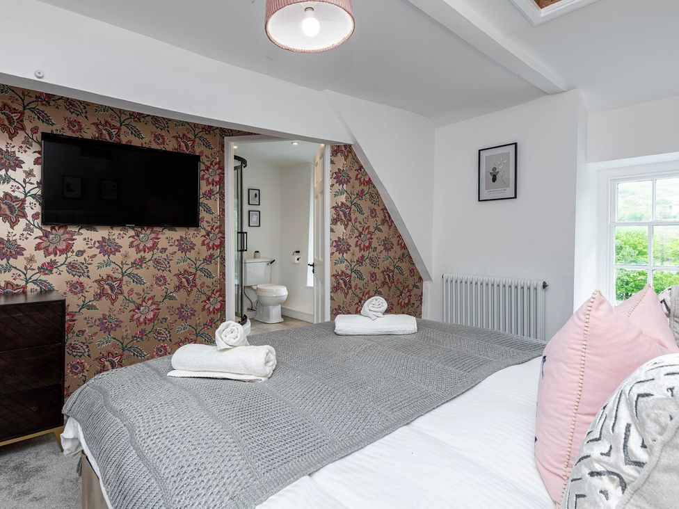 A bedroom with a bed and television at Snowdonia Manor in Dolgellau