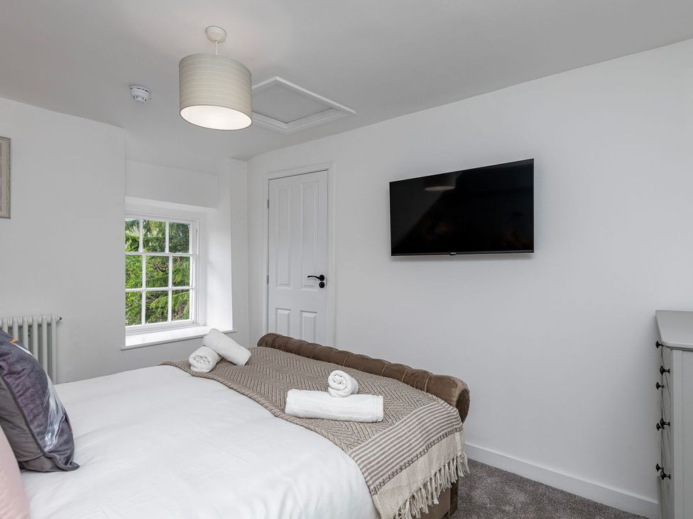 A bedroom with a bed and television at Snowdonia Manor in Dolgellau