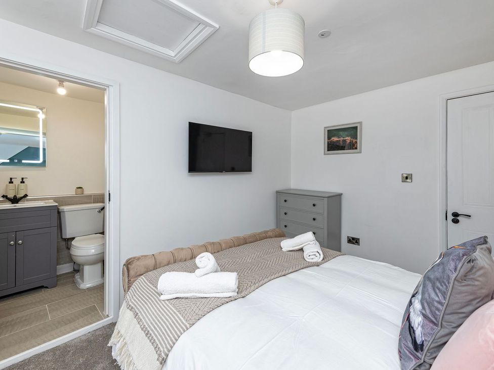 A bedroom with a bed and an attached bathroom at Snowdonia Manor in Dolgellau
