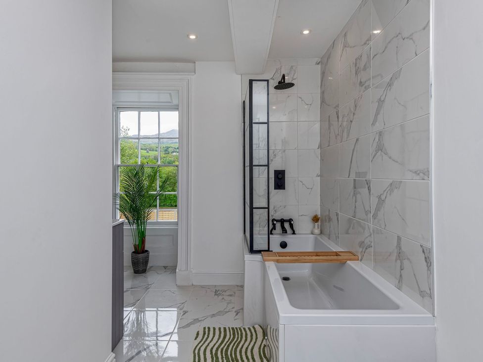 A bathroom featuring a bathtub and window at Snowdonia Manor in Dolgellau