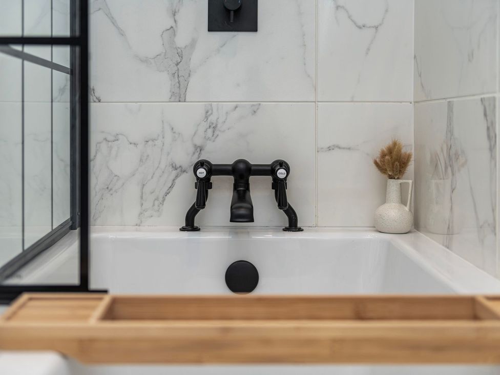 A bathroom with a bathtub and a faucet at Snowdonia Manor in Dolgellau