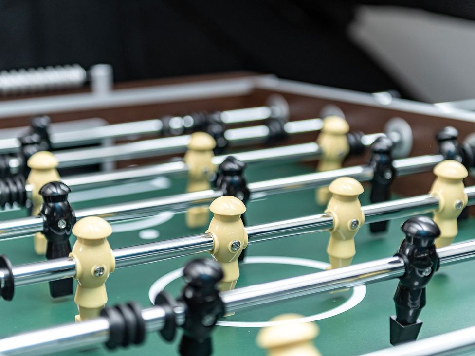 A foosball table with black and yellow players at Snowdonia Manor in Dolgellau