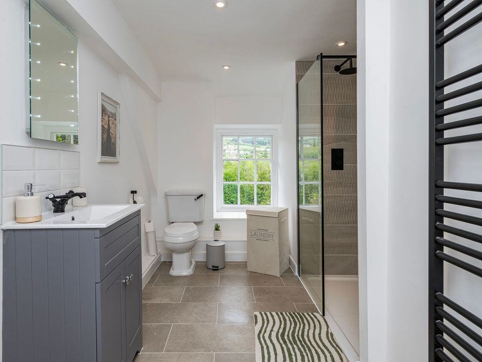 A bathroom with a sink, toilet, and shower at Snowdonia Manor in Dolgellau