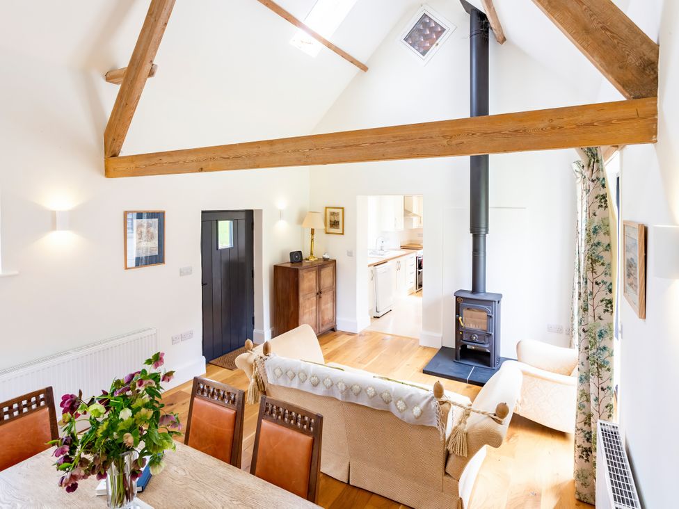 A living room with a wood stove and dining table at Johnsons Smallholding in Market Drayton