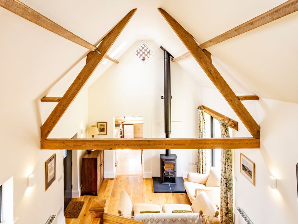 A living room with wooden beams and a stove at Johnsons Smallholding in Market Drayton