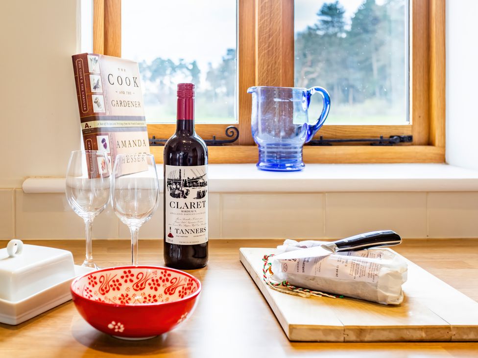 A kitchen with a wine bottle and glasses on a countertop at Johnsons Smallholding in Market Drayton