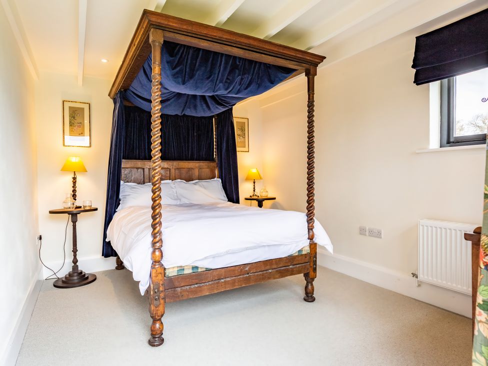 A bedroom with a four-poster bed and side tables at Johnsons Smallholding in Market Drayton