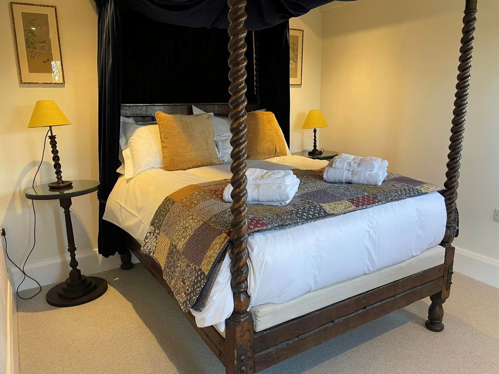 A bedroom with a four-poster bed and bedside lamps at Johnsons Smallholding in Market Drayton