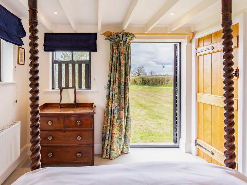 A bedroom with a dresser and window at Johnsons Smallholding in Market Drayton