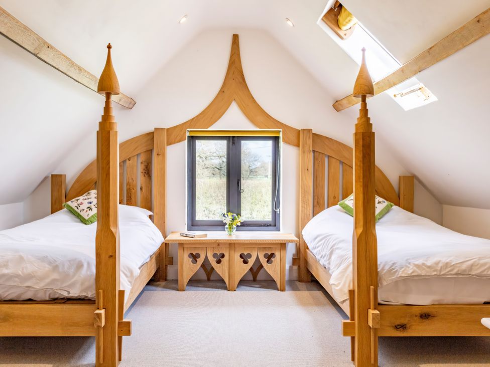 A bedroom with two beds and a window at Johnsons Smallholding in Market Drayton