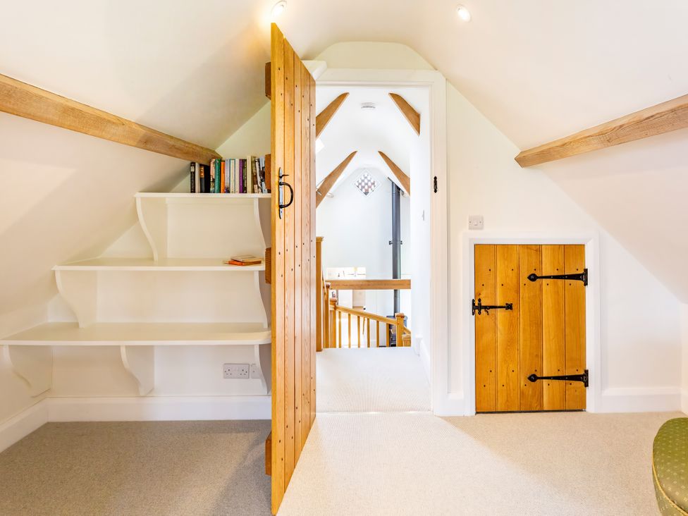 An attic with a bookshelf and doors at Johnsons Smallholding in Market Drayton