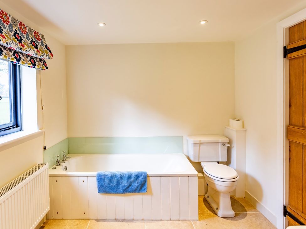 A bathroom with a bathtub, toilet and wash basin at Johnsons Smallholding in Market Drayton