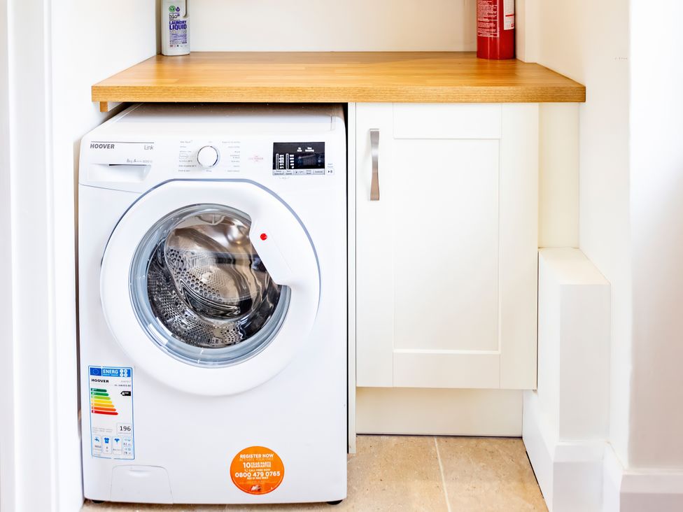 A washing machine under a wooden work surface at Johnsons Smallholding Market Drayton