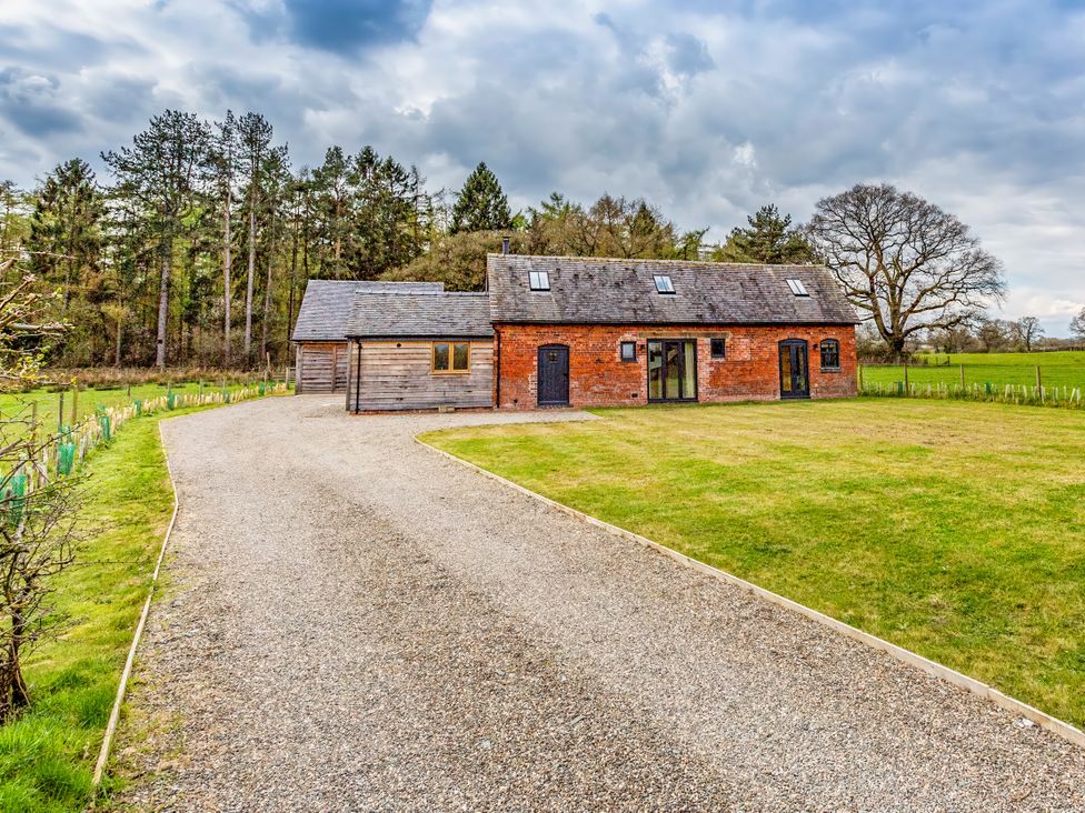 A house with a gravel driveway and garden at Johnsons Smallholding in Market Drayton