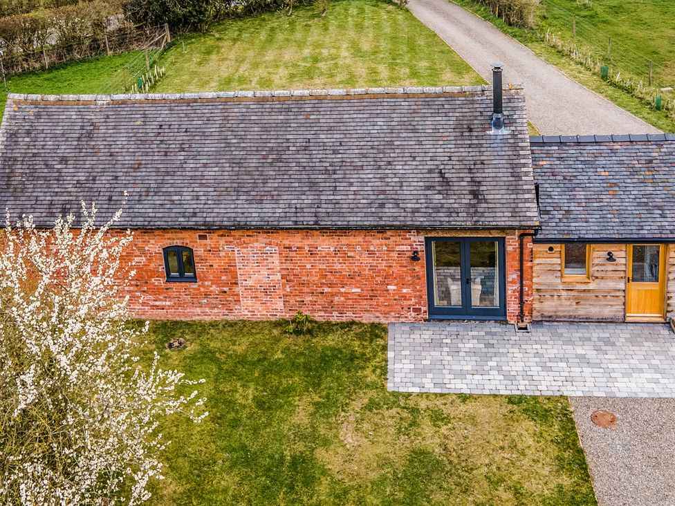 An exterior view of a house with brick walls and a patio at Johnsons Smallholding Market Drayton