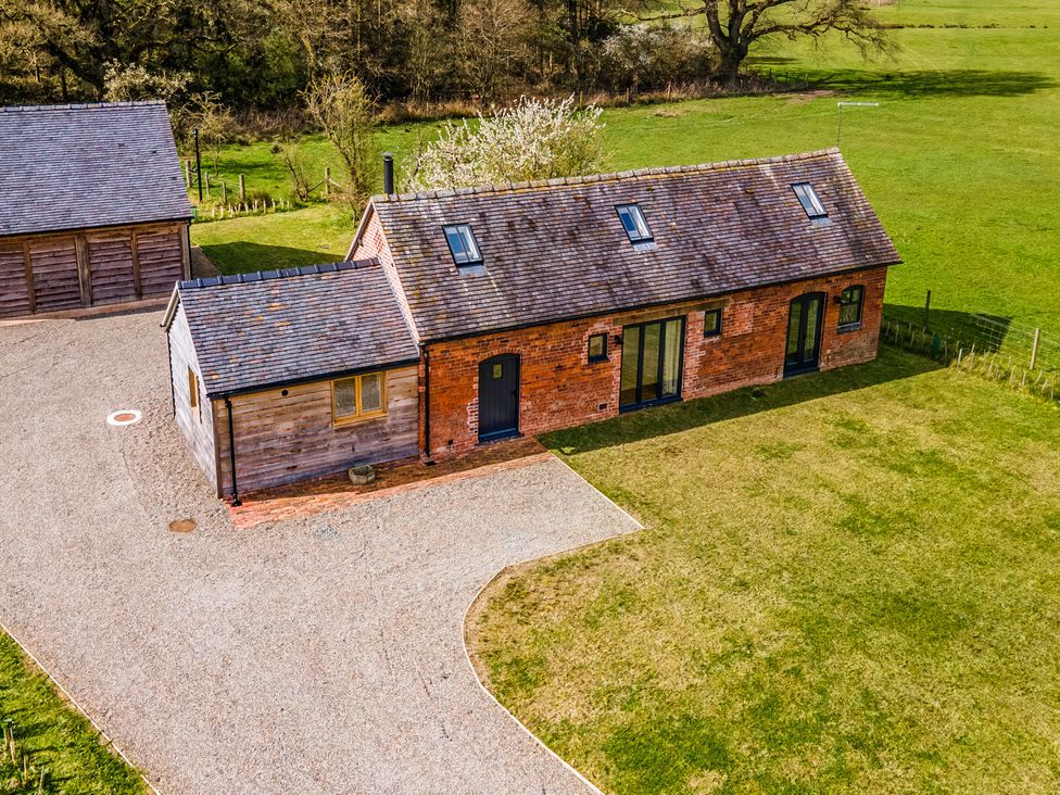 An exterior view of a house with a driveway and surrounding grass at Johnsons Smallholding Market Drayton