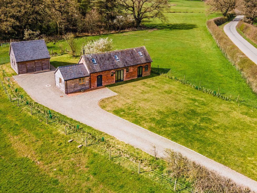 An outdoor view of a house and shed with a driveway at Johnsons Smallholding in Market Drayton